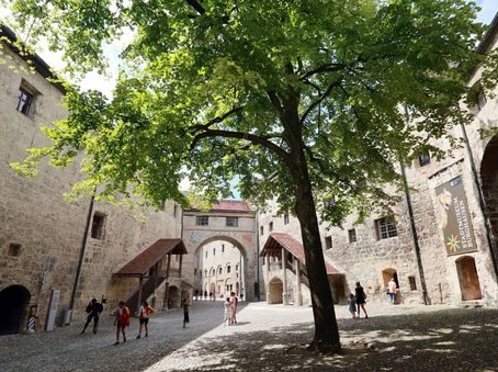 Innenhof der Hauptburg Burghausen mit Besuchern und Bäumen