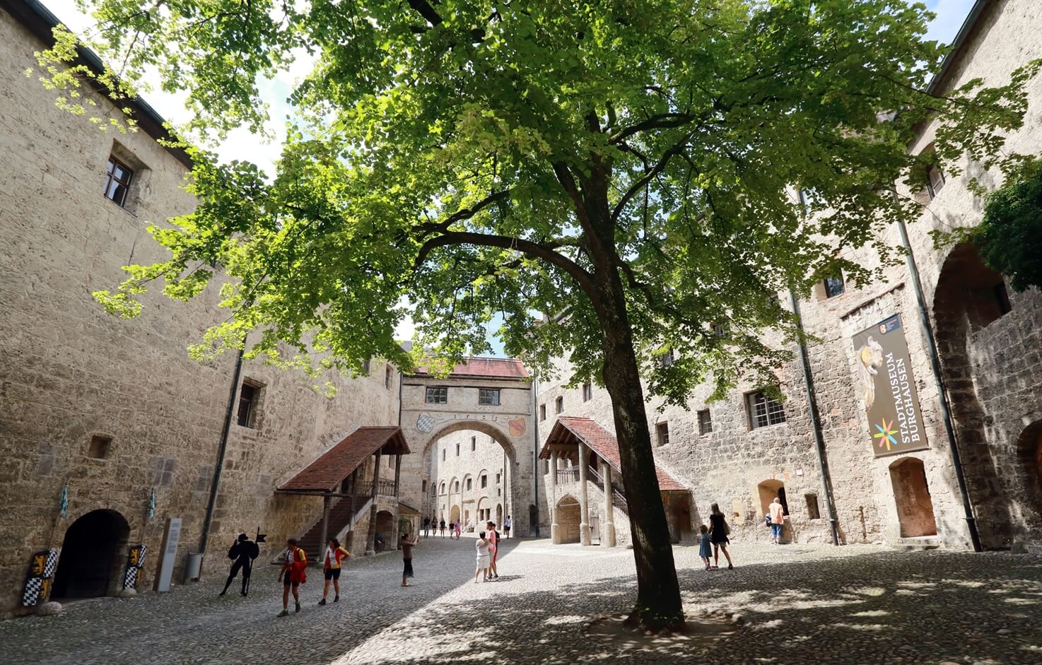 Innenhof der Hauptburg Burghausen mit Besuchern und Bäumen