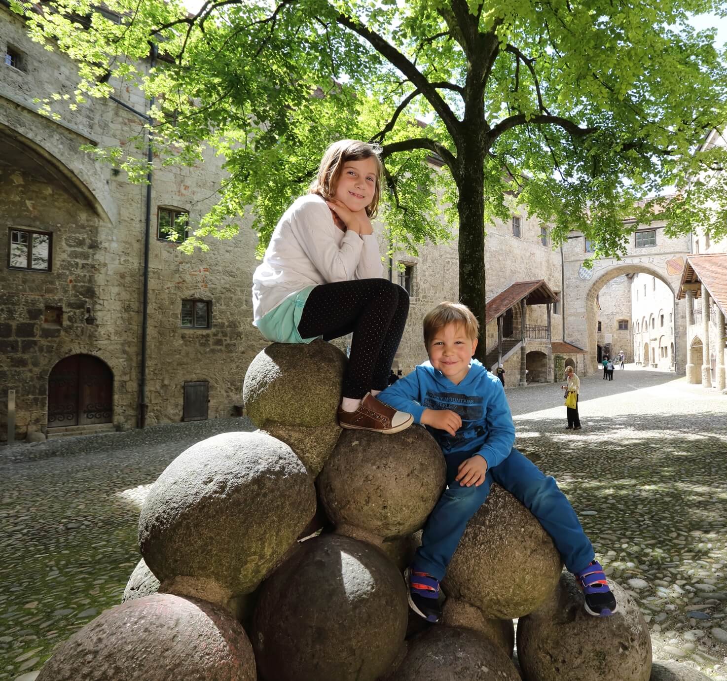 Junge und Mädchen auf Kanonenkugeln in der Hauptburg Burghausen