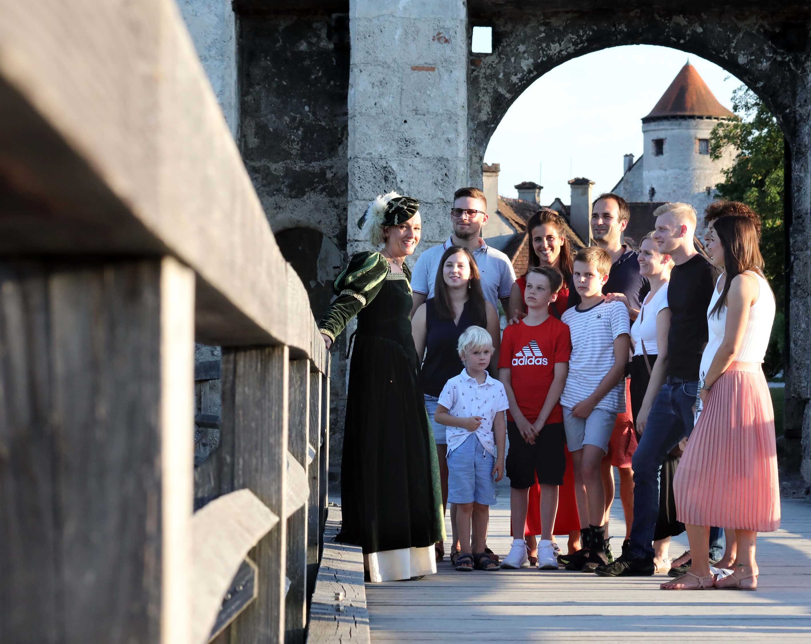 Gästeführerin historisch gewandet mit einer Gruppe auf der Brücke