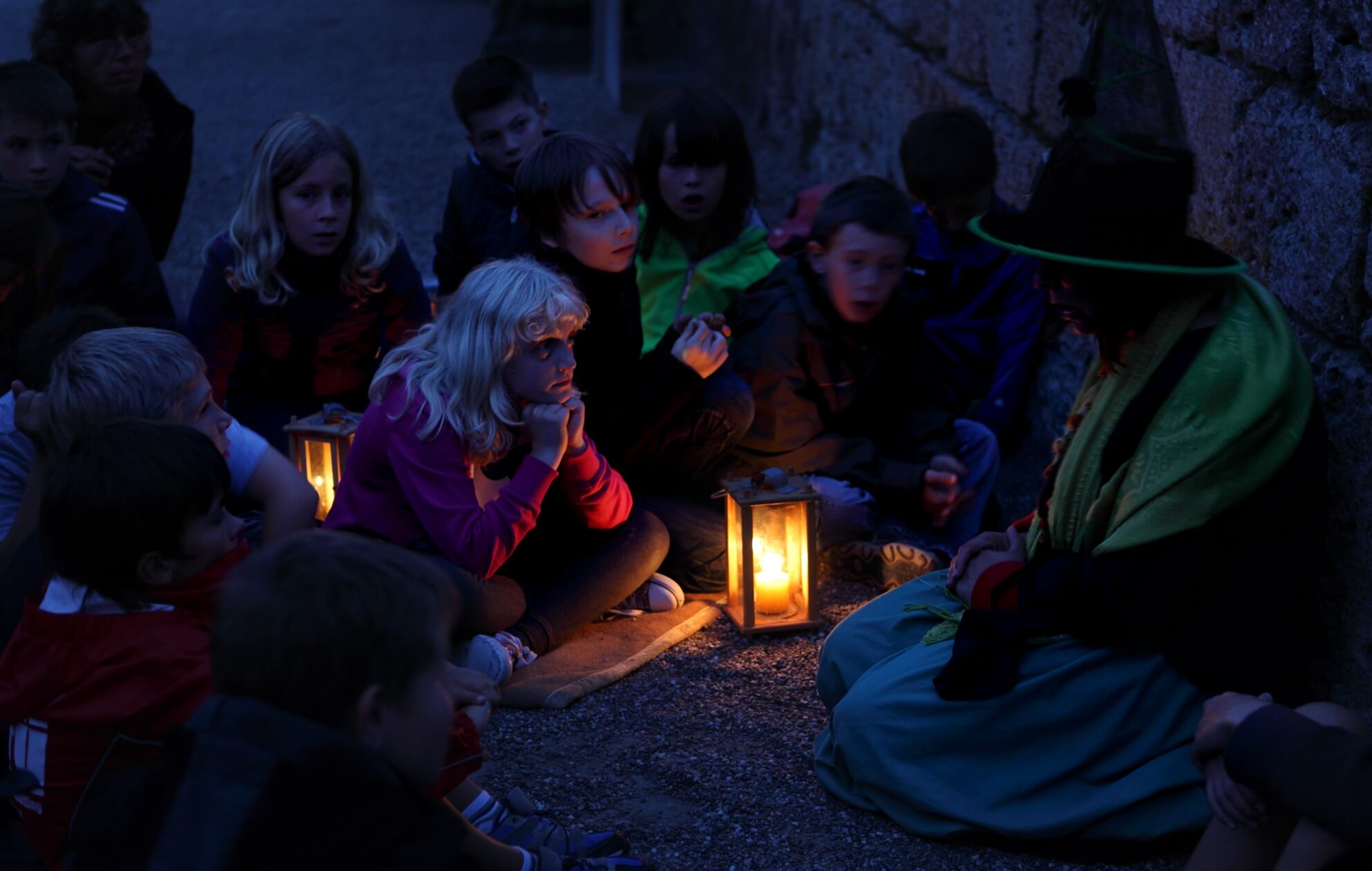 Gruselführung mit Gästeführer und Kindergruppe bei Dämmerung auf der Burghauser Burg